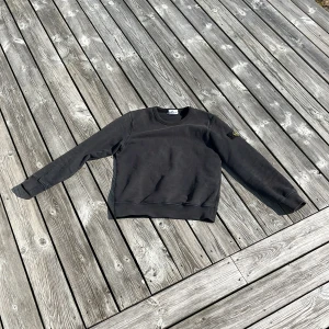 Stone island hoodie - Säljer min äkta stone Island hoodie, den tyvärr har blivit för liten för mig och är redo för en ny ägare,skick 9/10 men är rätt solbränd, priset må inte vara huget i stenen, hör av er vid minsta funderingar!! Obs passar folk mellan 150-161 cm, är inte uttöjd någon stans och ny pris från stone Islands hem sida där jag köpte den är 2200kr