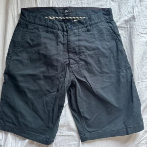Svarta shorts från Rip Curl - Snygga svarta shorts från Rip Curl med knapp och dragkedja framtill. De har fickor både fram och bak. Pris kan diskuteras