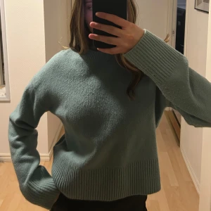 Grön stickad tröja - Mysig grön stickad tröja med ribbade detaljer. Superfin turkos/grön/mint färg och perfekt till lite vår/sommarkvällar men även till höst/vinter. Säljer pga flytt så måste bli av med lite kläder, lite nopprig men väldigt skön fortfarande, sticks inte alls.