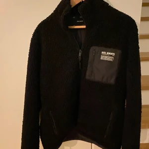 Axel Arigato fleecejacka - Säljer en svart fleecejacka från Axel Arigato med hög krage och dragkedja. Jackan har en bröstficka med dragkedja och tryckt logga samt två sidofickor. Perfekt för lager-på-lager och chill vardagsstil. Fler bilder kan självklart lösas!