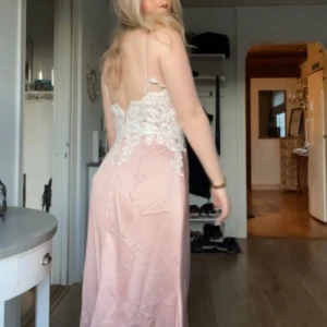Ljusrosa balklänning med spetsdetaljer - Jätte  ljusrosa balklänning med vit spets.  Perfekt för bal eller festliga tillfällen. Aldrig använt, alltså är den helt ny! Skulle säga att klänningen passar någon som har 36/38. 