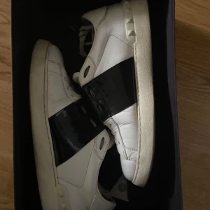 Valentino Open sneakers med svart band - Valentino garavani skor: valentino opens storlek 41 men passar även 42, ingår valentino kort, äktighetsbevis och två par extra skosnören. Skorna är i några månader och har små detekter, original pris nu för ca 6000. Säljer dom pga att dom har blivit för små. Tveka inte för att höra av dig vid frågor eller fler bilder📩