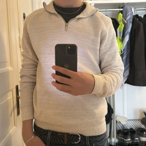 Beige stickad tröja med dragkedja från Primark - Säljer en beige stickad tröja från Primark med halv dragkedja i halsen. Tröjan har lång ärm, ribbade muddar och en klassisk krage. Perfekt för lager-på-lager och passar till många olika stilar.