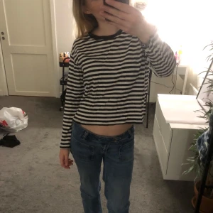 Svartvit randig långärmad tröja från Monki - Säljer en svartvit randig långärmad tröja från Monki i storlek XS. Tröjan är croppad med rund halsringning och tillverkad i mjuk bomull. Perfekt för en avslappnad och stilren look.