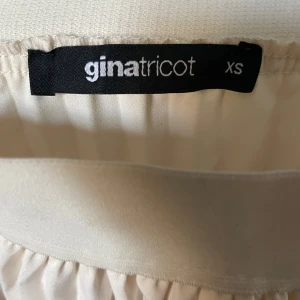 Beige plisserad kjol från Gina Tricot - Säljer en stilren beige tennis kjol från Gina Tricot i storlek XS. Kjolen har en elastisk midja för extra komfort och en vacker, flödande design. Perfekt för att skapa en elegant eller sportig look. 🌟