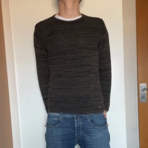 Mörkgrå randig stickad tröja från Solid - Säljer en mörkgrå stickad tröja från Solid Denmark i storlek M. Tröjan har ett diskret randigt mönster och rund halsringning. Riktigt grymt skick, endast använd 2-3 gånger, killen är 184 på bild.