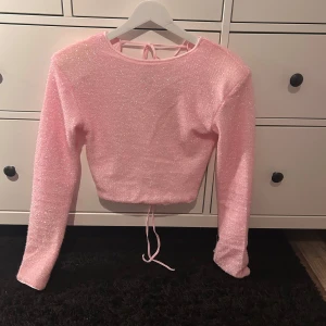 Rosa glittrig topp från BikBok - Säljer en rosa glittrig topp från BikBok med långa ärmar och knytband i ryggen. Perfekt för en festlig look! ✨ använd 1 kväll