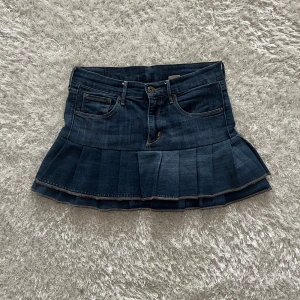 Jeanskjol med volang - Lågmidjad jeanskjol omsydd från ett par jeans. Midjemått tvärsöver- 37 cm Längd- 34cm 