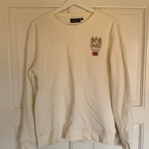 Vit sweatshirt från Morris - Säljer en stilren vit sweatshirt från Morris med broderad logga och brittisk flagga på bröstet. Då den inte längre passar mig och bara ligger i garderoben. 