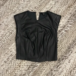 Svart läder topp  - Säljer en svart ärmlös topp från Amisu i skinnimitation. Köpt från New Yorker. Storlek S