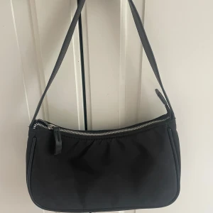 Svart axelväska med dragkedja - Säljer denna axelväska. Den har äkta skin detaljer. (Randen som går längs väskan) Som ny. Används endast 2-3 gånger.🌸Nypris 600kr