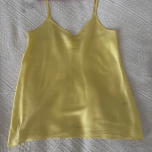 Gul silkeslinnetopp från From Future - Superfin ljusgul linnetopp i 100% silke från From Future. Topp med smala, justerbara axelband och v-ringning. 