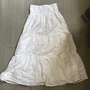 Vit långkjol med broderade detaljer - Superfin vit långkjol i bomull med broderade blommor och smock i midjan. Kjolen är från Gina ,helt slutsåld med prislapp kvar. Snygg att styla med crop top eller linne för en chill sommarlook. Originalpris :300 Mitt pris:190❤️ storlek 146-152/ tar emot bud!