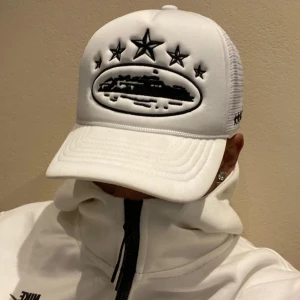 Vit Corteiz Trucker cap - Säljer en vit Corteiz trucker cap. Kepsen är i perfekt skick då den aldrig har använts. Tveka inte på att höra av dig vid minsta fråga eller fundering! 