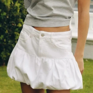 Vit bubbel kjol Zara  - Supersöt vit kortkjol i jeans med bubblig volang nertill och klassiska fickor framtill. 