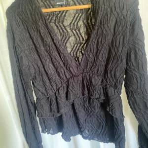 Svart volangtopp  - Säljer denna söta blus från Gina Tricot! Endast använd en gång så är därför i väldigt bra skick💕