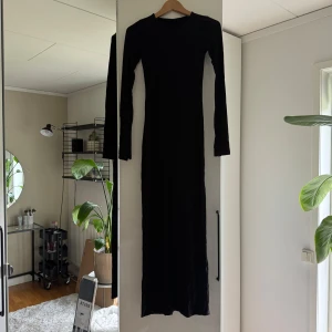 Svart långärmad långklänning - En svart, figurnära långklänning med långa ärmar med slits och rund hals. Klänningen är från Ginatricot och funkar utmärkt att använda vid de flesta sammanhang. Ett fantastiskt plagg att ha i garderoben🥰😇