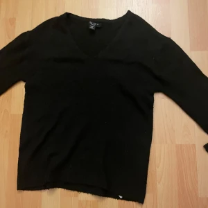 Svart stickad v-ringad tröja  - Svart stickad tröja från New Yorker med v-ringning och långa ärmar. Tröjan har ribbade muddar vid ärmsluten och en klassisk, enkel design som funkar till det mesta. Perfekt för dig som gillar basic men ändå vill ha det snyggt.