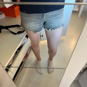 Lågmidjade jeansshorts  - Snygga gråa Lågmidjade jeansshorts med fransig kant och fickor där bak. Perfekta nu för sommaren men även tidig höst, våren och helt enkelt varmare väder. De är köpta från Gina och är k storlek 164. Shortsen är aldrig använda och därav i ett mycket bra skick! 