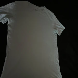 Turkos basic t-shirt från SOC - Enkel och stilren. Turkos t-shirt från SOC i klassisk modell. T-shirten har rund halsringning och korta ärmar, perfekt för en clean och avslappnad look. Tillverkad i mjuk bomull som känns skön mot huden.