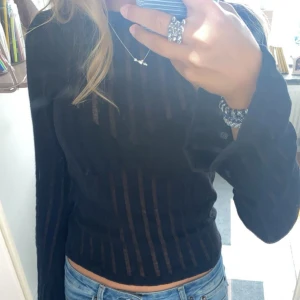 Svart randig långärmad tröja - Svart långärmad tröja med tunna ränder som är en genomskinliga. 