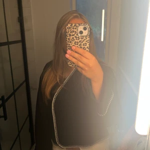 Filtjacka - Snygg svart filtjacka med markerade vita sömmar längs kanterna. Modellen är öppen framtill och har en lite boxig, loose passform. Perfekt att slänga över en topp för en stilren look. Passar både till jeans och kjol. Tråden har lossnat en aning vid kragen men inget som syns