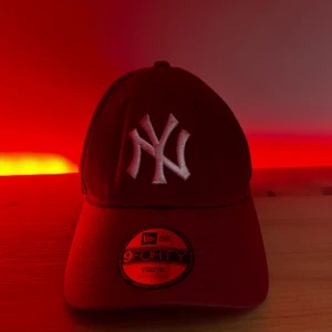 New York Yankees Vinröd - Snygg röd keps från New Era med broderad vit logga framtill. Justerbar rem baktill för perfekt passform. Perfekt för en sportig look eller som en stilren accessoar. storlek:youth