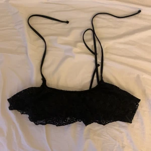 Svart spetsbikini från H&M - Snygg svart bikiniöverdel från H&M i spetsdesign med knytband. Aldrig använd. Den har ”vaddering” eller vad man ska säga, men det går att ta ut. Storlek 36. Fråga gärna om du vill ha mått eller undrar något annat!💗