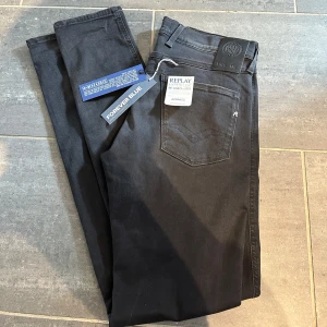 Replay Anbass Hyperflex ( helt nya ) - Snygga svarta jeans från Replay i modellen Anbass. De har en klassisk femficksdesign och en stilren look. Perfekta för dig som gillar en modern och tidlös stil.