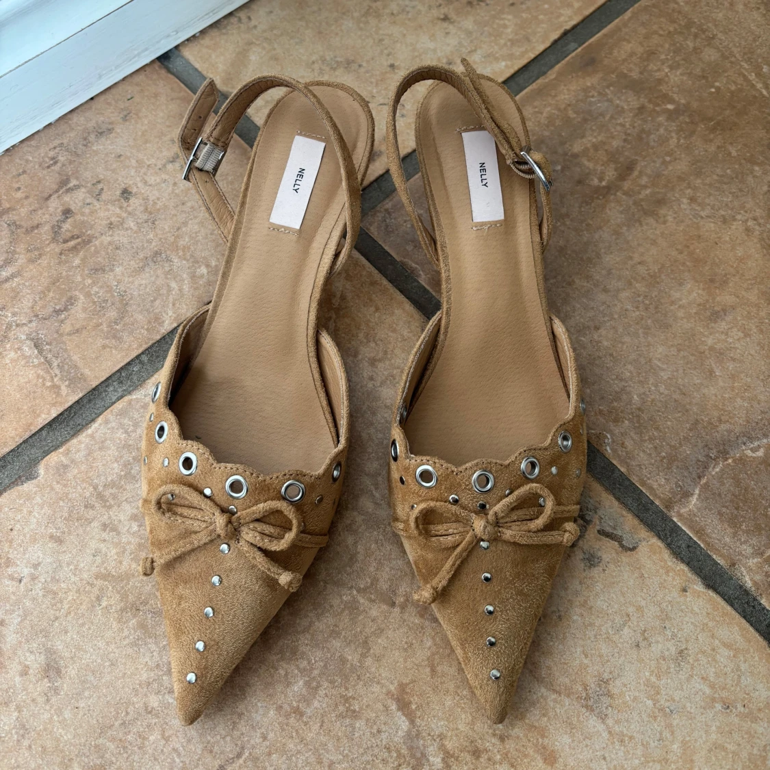 Beige pumps med spetsig tå och rosett