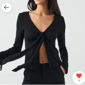 Svart långärmad topp med knyt - Snygg svart långärmad topp med v-ringning och knyt framtill. Perfekt för en stilren look. Andvänd 1 gång. 💞💞💞