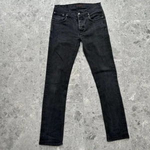 Svarta jeans från Nudie Jeans - Snygga svarta jeans från Nudie Jeans med klassisk femficksdesign och knappgylf. De har en stilren look med diskreta sömmar och en bekväm passform. Storlek 32/32 men passar 28/30. Pris kan diskuteras 