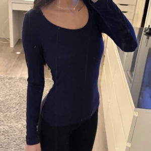 Mörkblå långärmad topp - Säljer en stilren mörkblå långärmad topp med rund halsringning. Perfekt för en enkel och elegant look. 