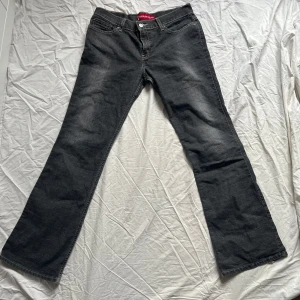 Grå jeansbyxor från Levi's - Snygga grå lågmidjade jeansbyxor från Levi's med en låg midja och bootcut-stil. 