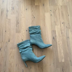 Jeans klackar  - Snygga jeans klackar med spetsig tå och hög klack. De har en rynkad design som ger en trendig look. Perfekta för att lyfta vilken outfit som helst.