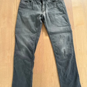 Grå jeansbyxor från Acne Studios - Snygga grå jeansbyxor från Acne Studios i modellen Max Darko. Byxorna har en klassisk femficksdesign och normal passform. Perfekta för en stilren look.