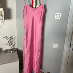 Rosa långklänning med smala axelband - Säljer en rosa långklänning med smala axelband. Aldrig använd så prislapp kvar!