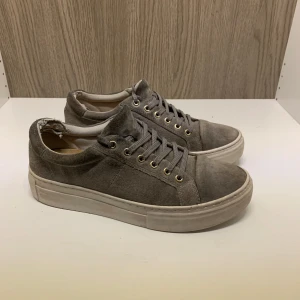 Vagabond skor - Snygga grå sneakers med snörning och rund tå. Skorna har en stilren design med en vit sula och gyllene öljetter för snörena. Perfekta för en avslappnad stil. Är stolek 38 men skulle säga att dom passar 39. Box finns om man vill ha med de