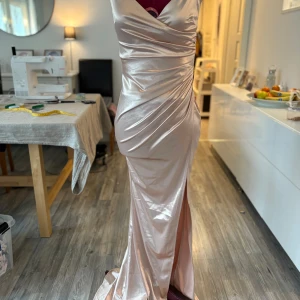 Champagnefärgad balklänning - Fin champagnefärgad bal/festklänning som aldrig hat använts. Säljs då jag hittade en annan klänning istället.