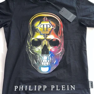 Svart t-shirt med dödskalletryck från Philipp Plein - 3 svarta Philipp Plein tröjor, har ingen bild på den tredje, har en video om man är intresserad får man skriva. Säljer dem billigt pågrund av används länge men är fortfarande i fint skick, säljer en för 1500 men alla tre för 3000, 2 för 2000. Finns chans att jag kan diskutera pris, bara vid snabba köp säljer redan billigt. Skriv om man är intresserad får man bättre bilder på tröjorna. Tröjan är o S men passar I M. Perfekta tröjor till sommaren. 