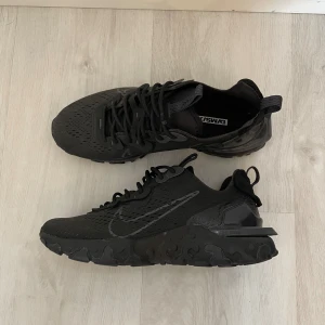 Nike React V2 - Säljer mina hel svarta nike react v2 i storlek 42. Helt nya aldrig använda, därav inga skador eller liknande på dem. 