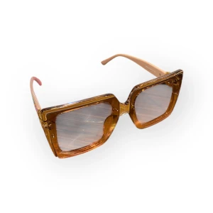 Bruna fyrkantiga solglasögon  - Snygga solglasögon  med fyrkantig form och transparent brun båge. Sidorna är ljusbeige med guldiga G-loggor och detaljer. Perfekt accessoar för dig som vill sticka ut med en trendig look.