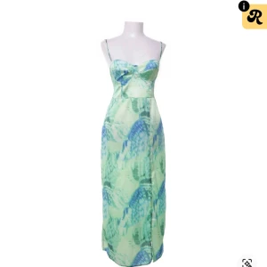 Grön och blå långklänning med mönster - Säljer en snygg långklänning i grönt och blått med tunna axelband med mönster. Klänningen har öppen rygg med snörning och är perfekt för sommaren. 💚🌻