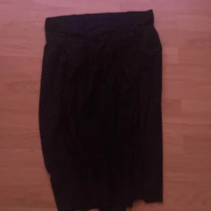 Svart kjol från Newhouse - Säljer en svart kjol från Newhouse. Kjolen har en klassisk rak modell och är vadlång, perfekt för dig som gillar stilrena plagg. Passar till många olika tillfällen och är enkel att matcha med olika toppar.