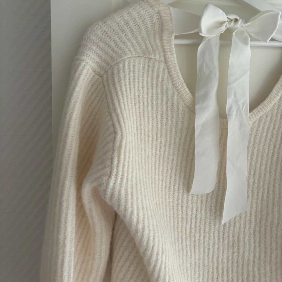 Beige stickad tröja med rosett