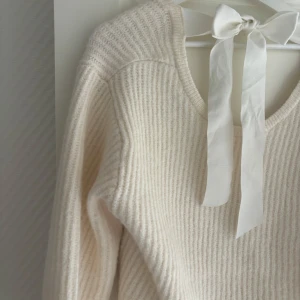 Beige stickad tröja med rosett - Superfin beige stickad tröja med rosett i ryggen! Perfekt till sommarkvällar🌸