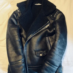 ZARA jacka – Storlek S - Snygg och varm biker-inspirerad jacka från ZARA i storlek S. Fodrad med mjukt teddyfoder, perfekt för kallare dagar. Svart, i fint och bra skick utan några större skavanker, skador eller synligt slitage.
