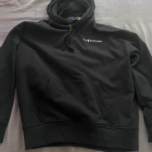 Svart hoodie från Polo Ralph Lauren - Säljer en jättefin svart hoodie från Polo Ralph Lauren med broderad logga på bröstet. Köpt på NK för 2100 kr! Skulle vara en present till min pappa men den passade tyvärr inte. Så den är helt ny och oanvänd. Storlek M/L. Skriv vid frågor, postar snabbt! 🖤.  