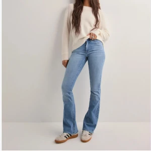 Ljusblå bootcut jeans från ONLY - Säljer ett par ljusblå bootcut jeans från ONLY med medelhög midja och klassisk femficksdesign. Jeansen har dragkedja och knapp framtill samt raka ben med lätt utsvängd nederdel. Perfekta för en avslappnad och trendig look. Storlek XS med längd 34