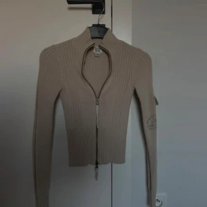 Stickad kofta - Beige stickad kofta med zip och halv polo , croppad och tight passform från BDG / Urban Outfitters